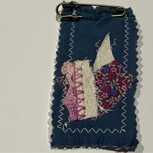 Navy quilted decorative patch.  The patch has a pin as closure.
